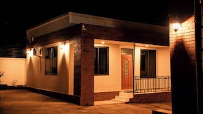 Una casa moderna con facciata in mattoni, un portone d'ingresso e un piccolo portico con ringhiera.