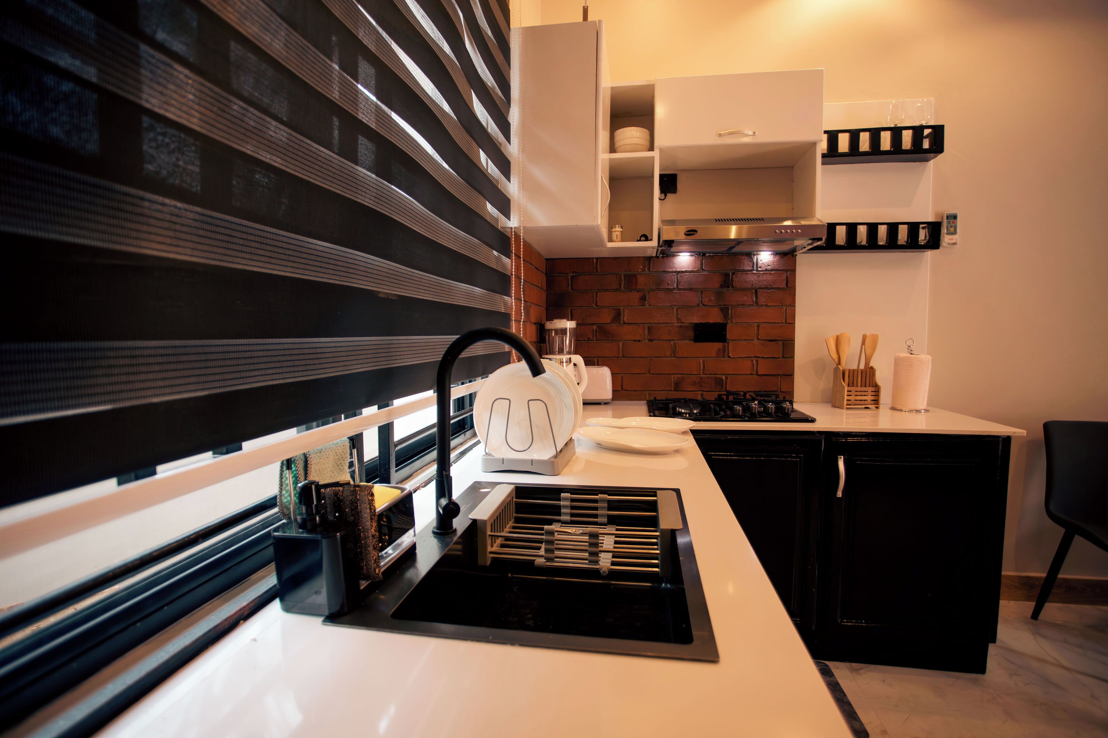 Una cucina moderna con schema di colori bianco e nero, dotata di forno integrato, cappa aspirante ed elettrodomestici.