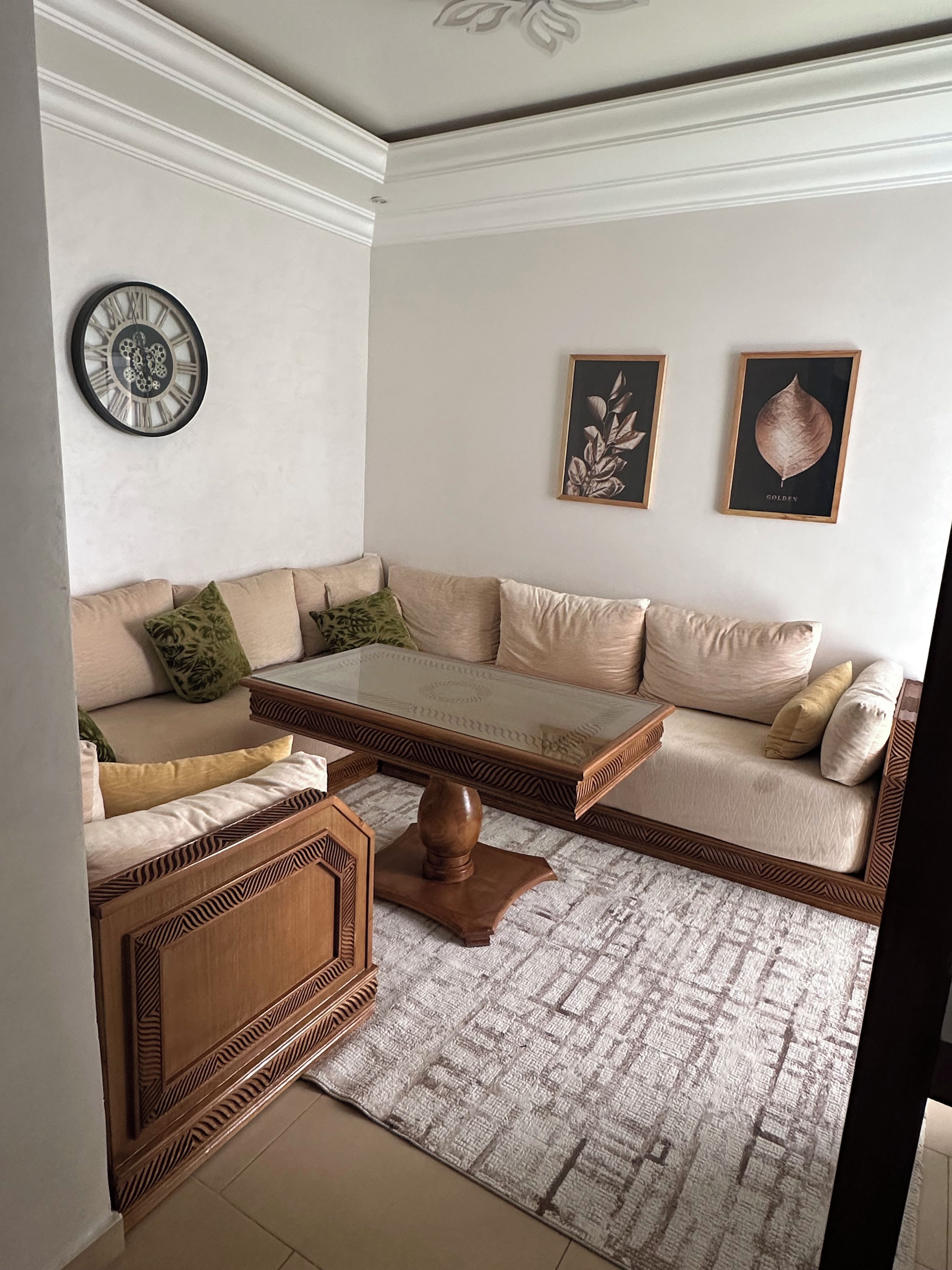 Un salon avec un canapé, une table basse et des coussins décoratifs.