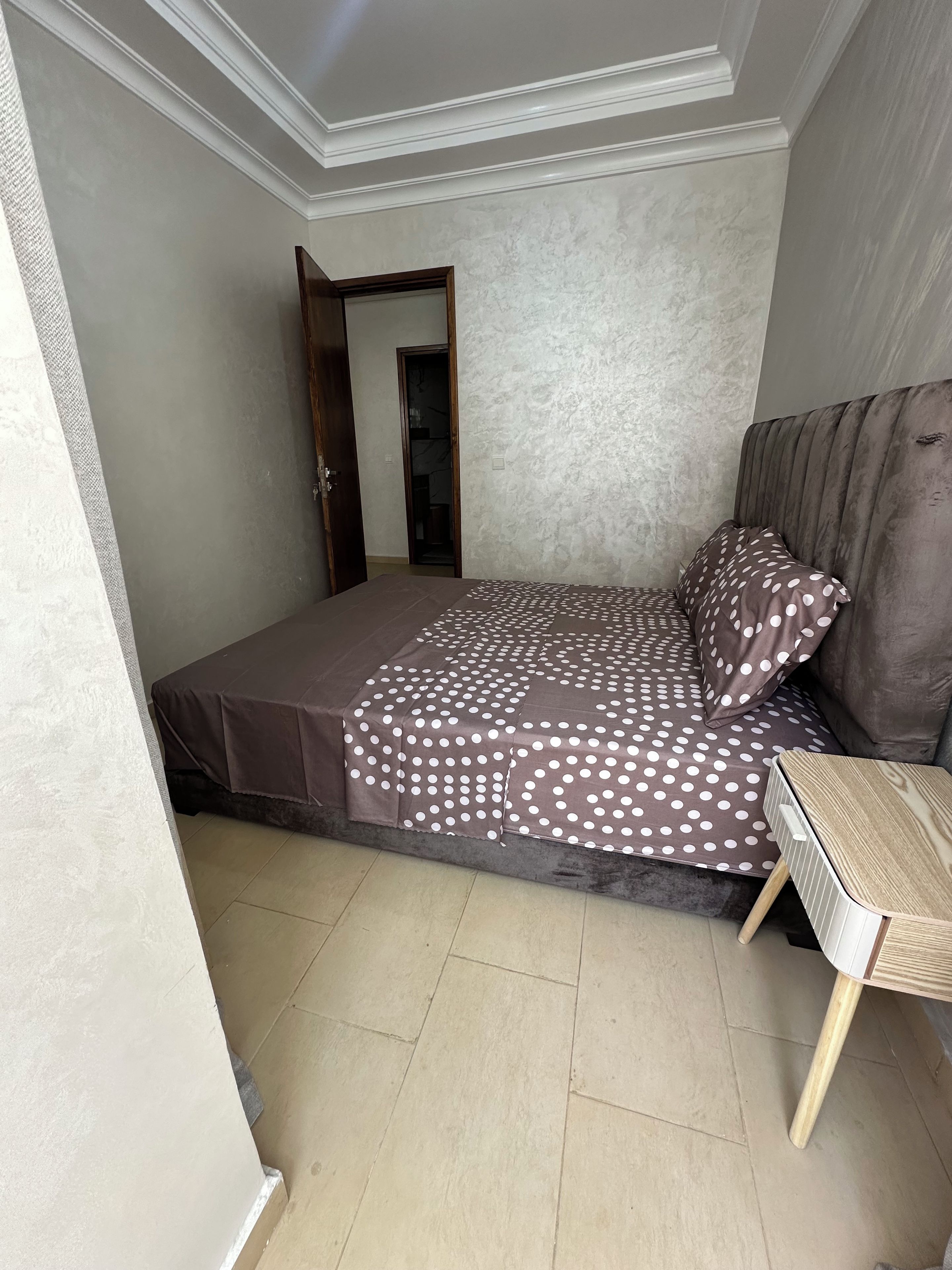 Une chambre à coucher avec un lit, une table de chevet et une armoire.