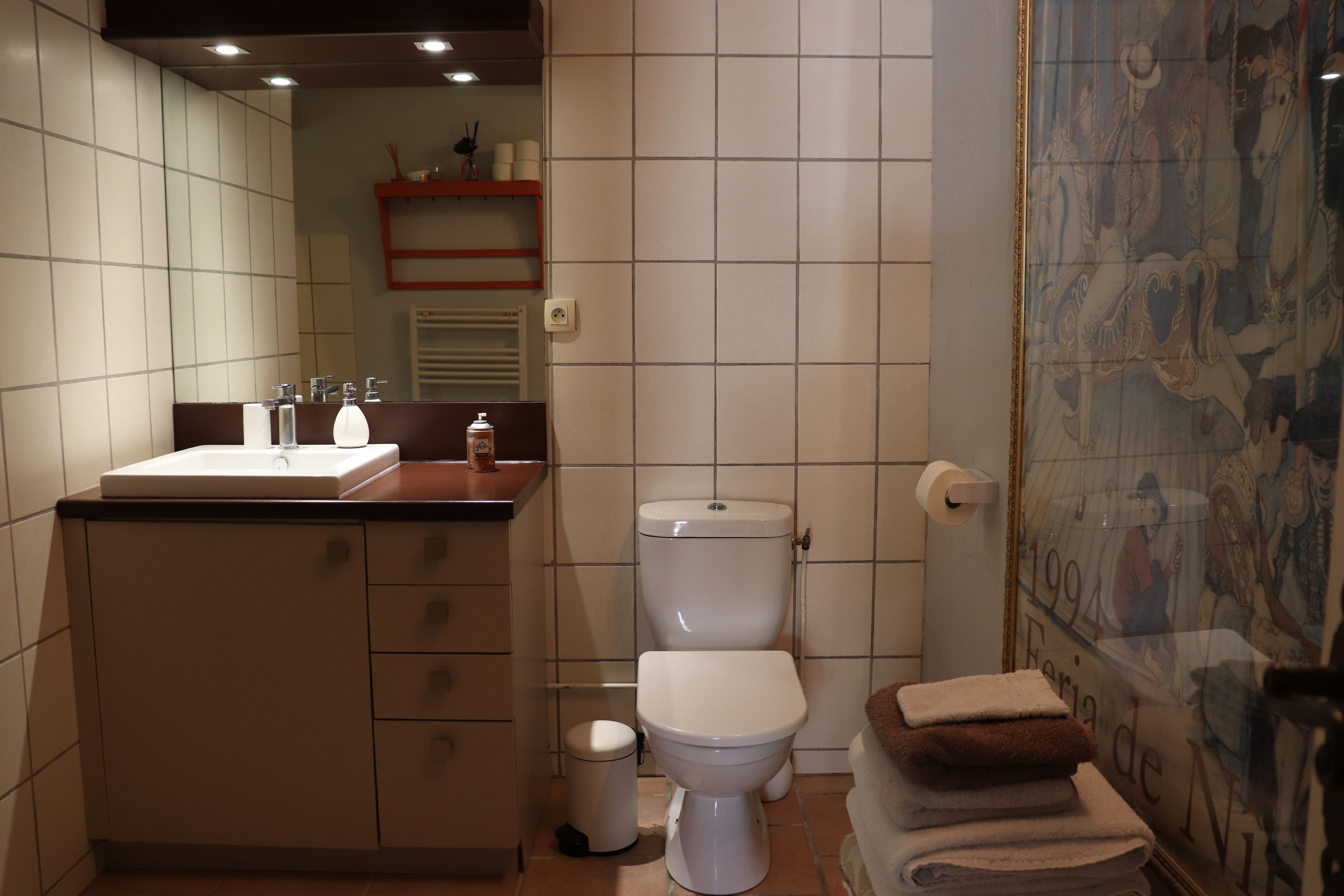 Un bagno con il water, un lavandino e uno specchio.