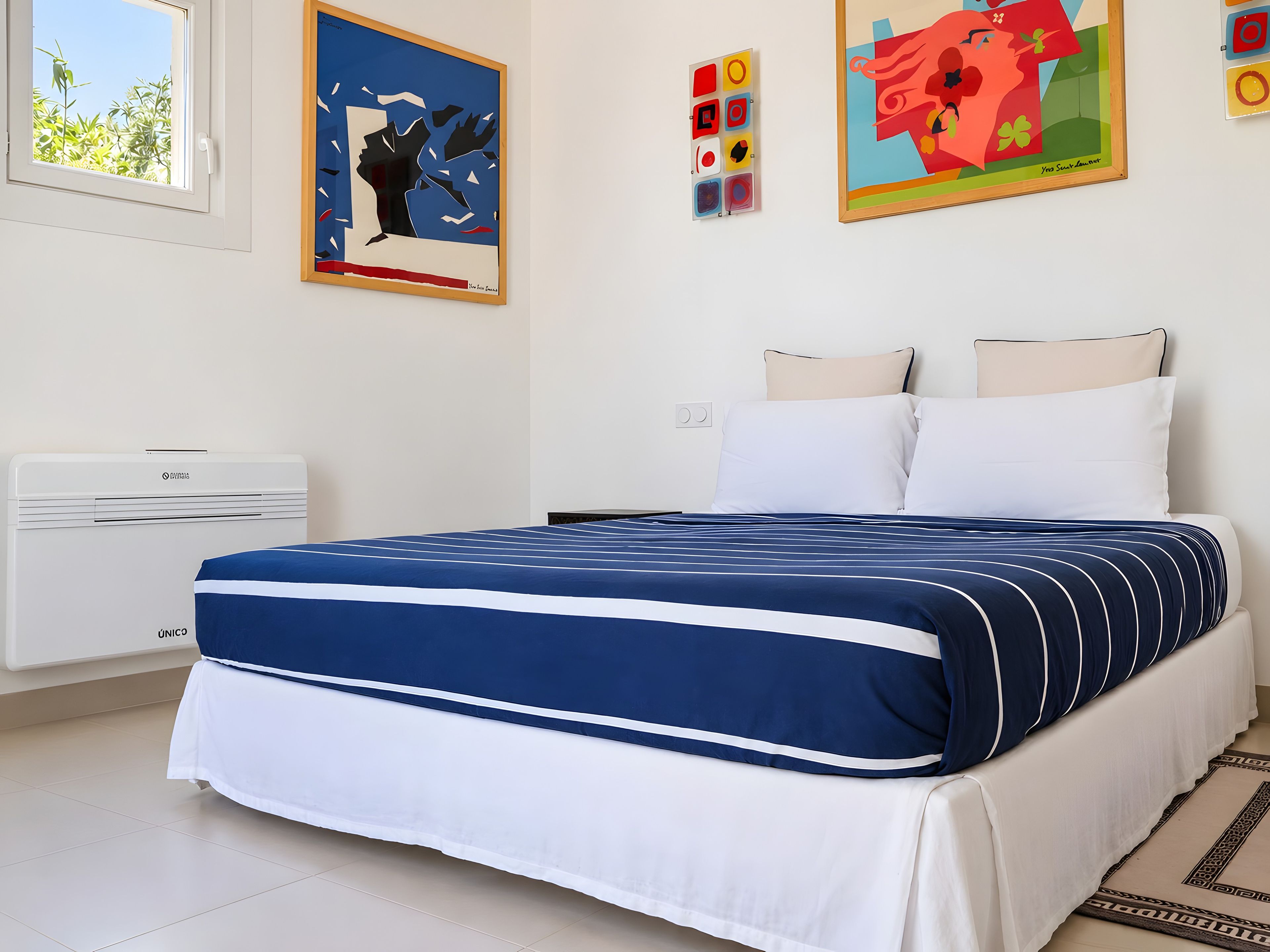 Una camera da letto con un letto, una finestra e un condizionatore d'aria a muro.