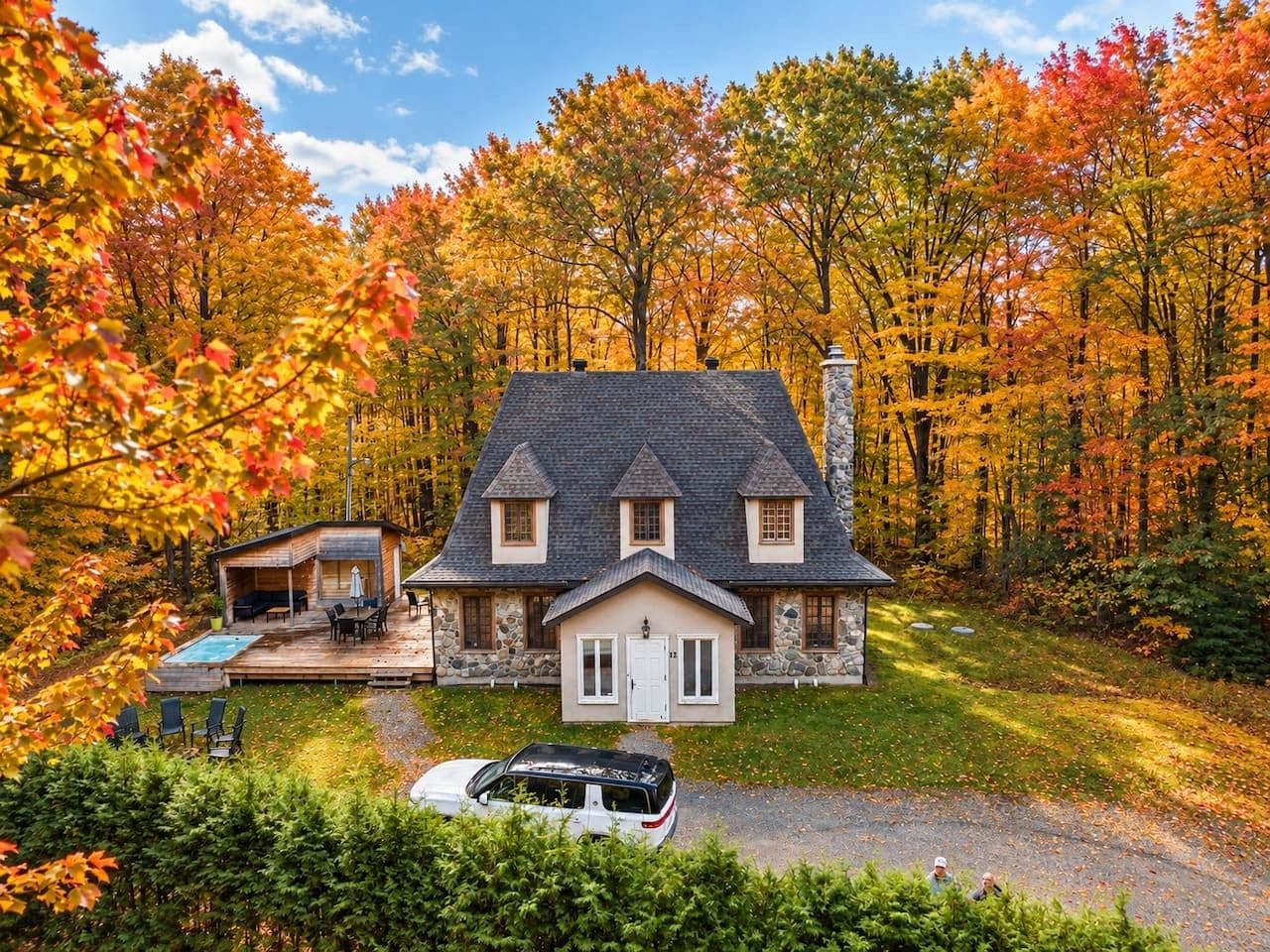 A two-story house with a stone exterior, a front porch, and a small attached garage.