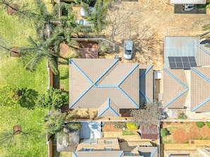 Vista aérea de uma área residencial com várias casas, algumas com telhados inclinados e outras com telhados planos.