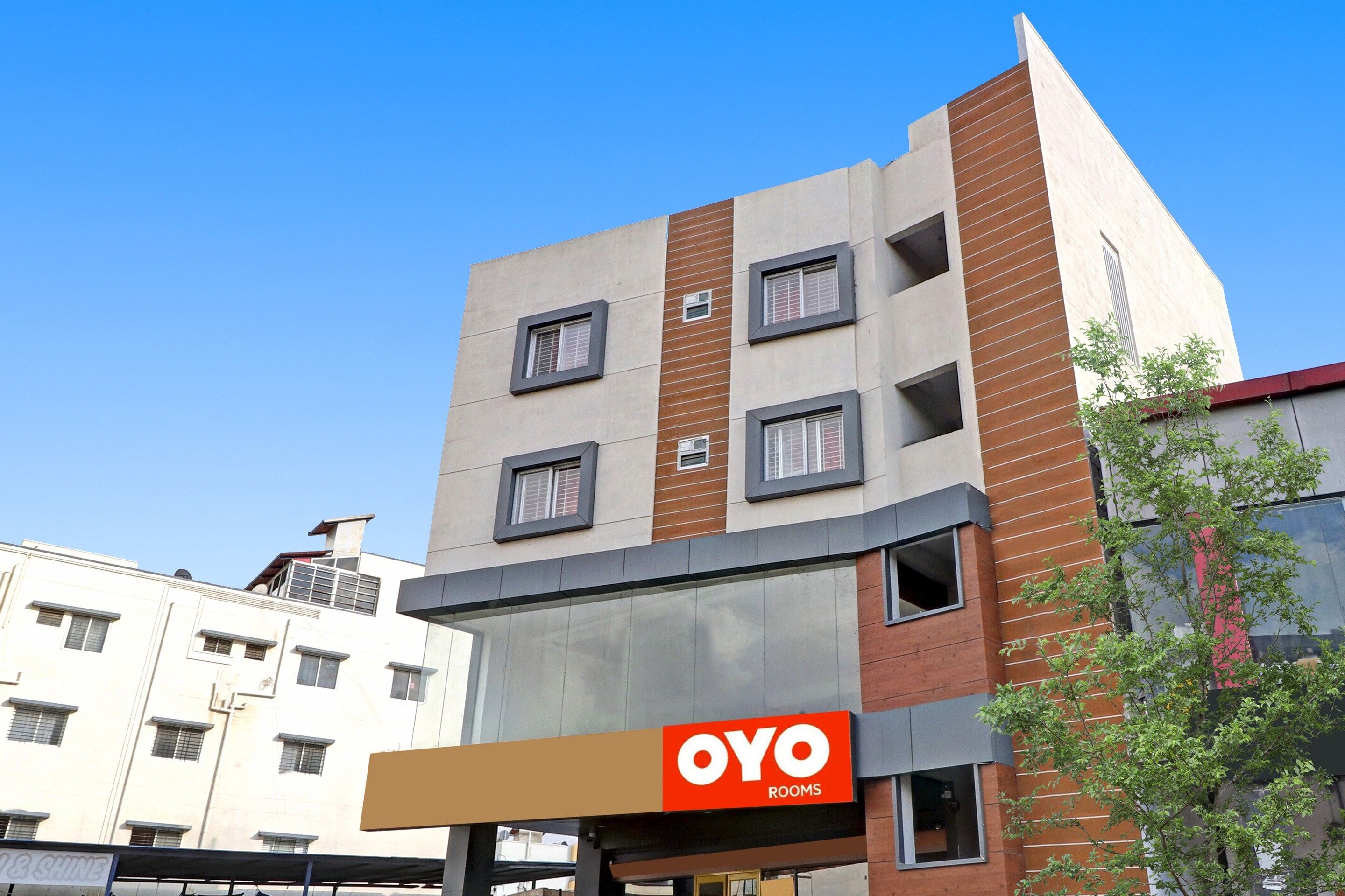 En flervåningsbyggnad med en tydlig skylt som visar texten ”OYO ROOMS”.