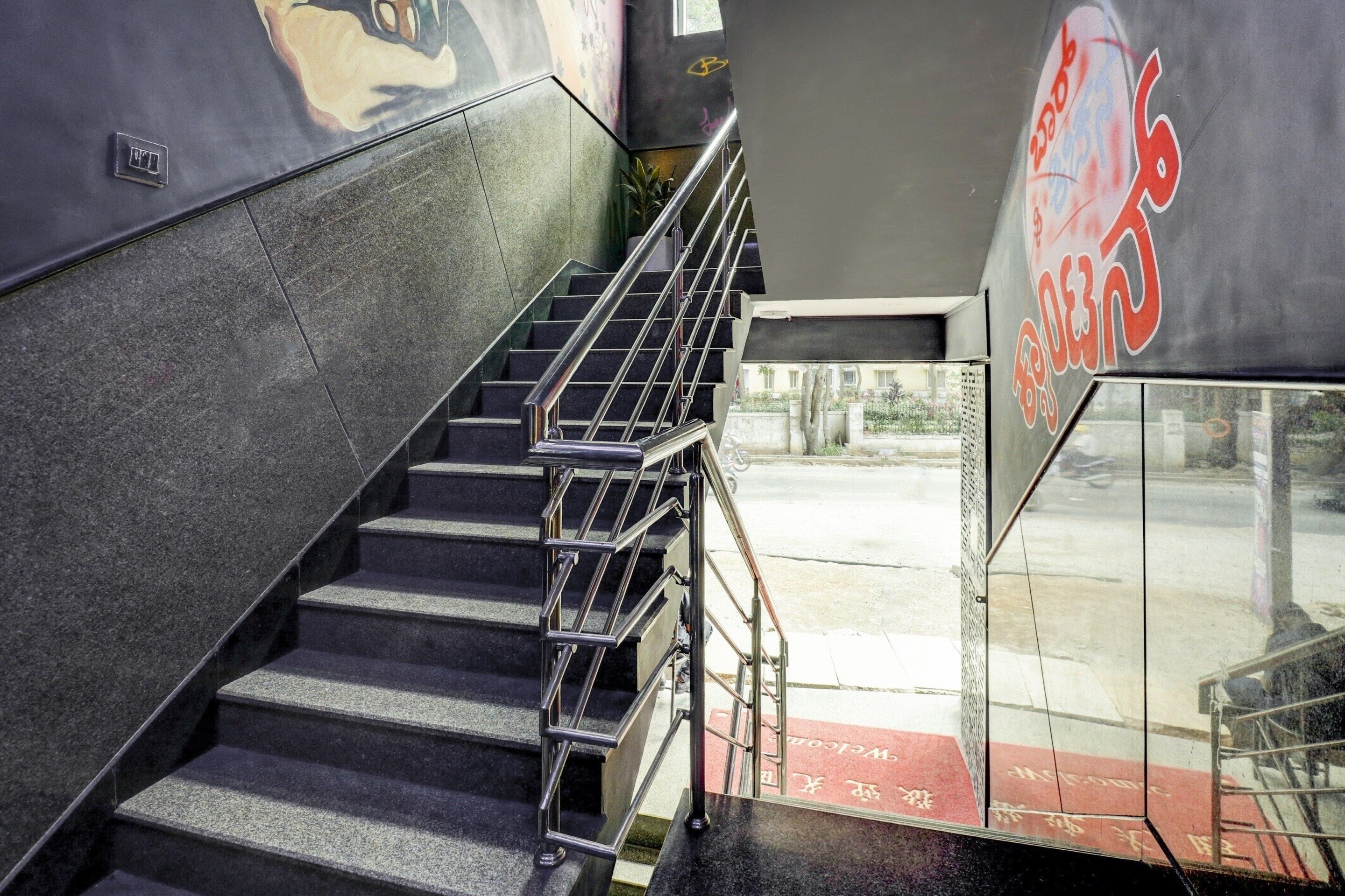 Una escalera con barandillas de metal que baja a un nivel inferior.