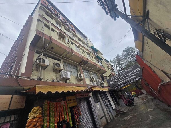 Un edificio de varios pisos con un letrero que indica Hotel Sai Vishram.