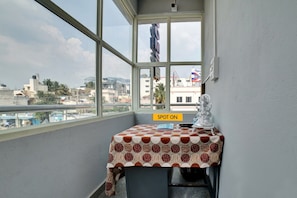 Un balcón con una mesa, vistas de la ciudad y un cartel que dice 'SPOT ON'.
