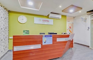 A reception desk with a clock, a sign for 'GOYAL Residency Executive Rooms,' and a reception area with a reception counter. - Collection O Goyal Residency (Bangalore)