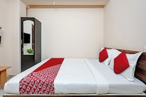 Un dormitorio con una cama, un armario y un espejo.