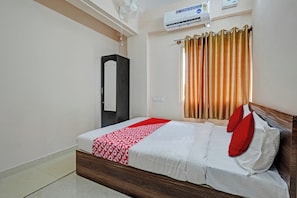 A hotel room with a bed, a wardrobe, an air conditioning unit, and a window with curtains. - Hotel O Sri Ranga Boarding & Lodging (Bangalore)