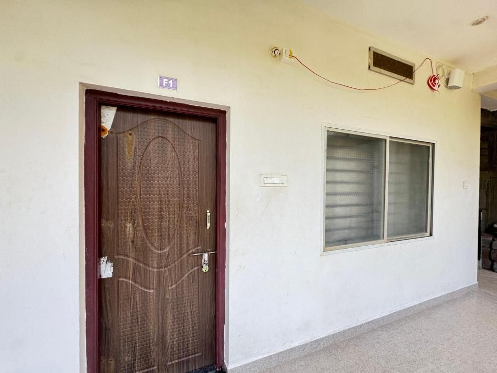 A door with a number plate, a window, and a wall-mounted air conditioning unit.