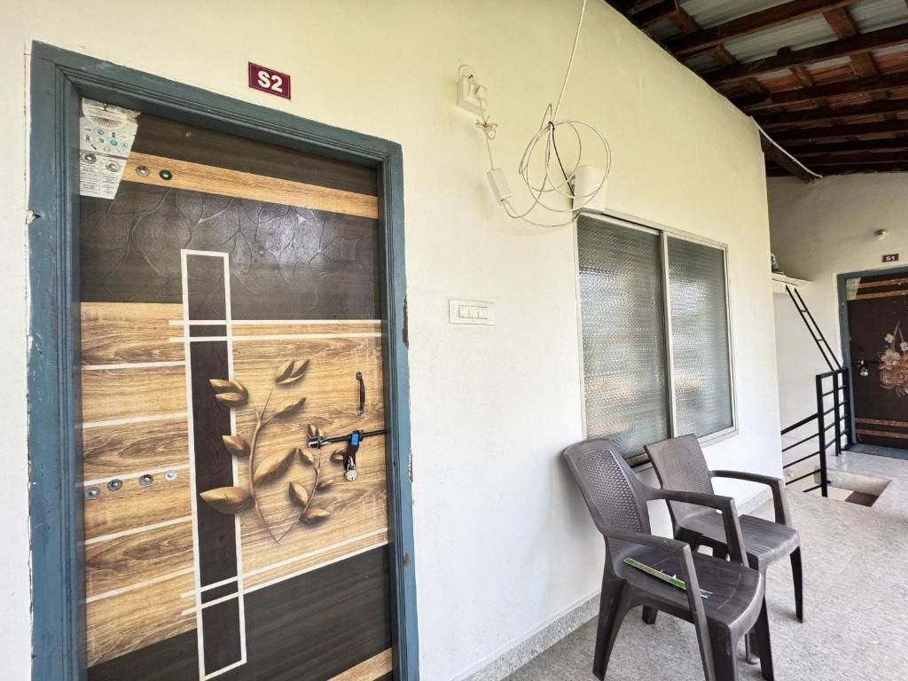Una habitació amb una porta de fusta, una cadira i una escala.