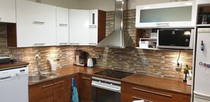 A modern kitchen with white cabinets, a built-in stove, and a Bosch microwave. - River landscape close to the centre, Himos 8km (Jämsä)