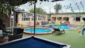 Área de piscina com espreguiçadeiras, piscina e um lounge VIP.