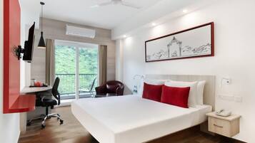 Una habitación de hotel moderna con una cama grande, un escritorio y una silla.