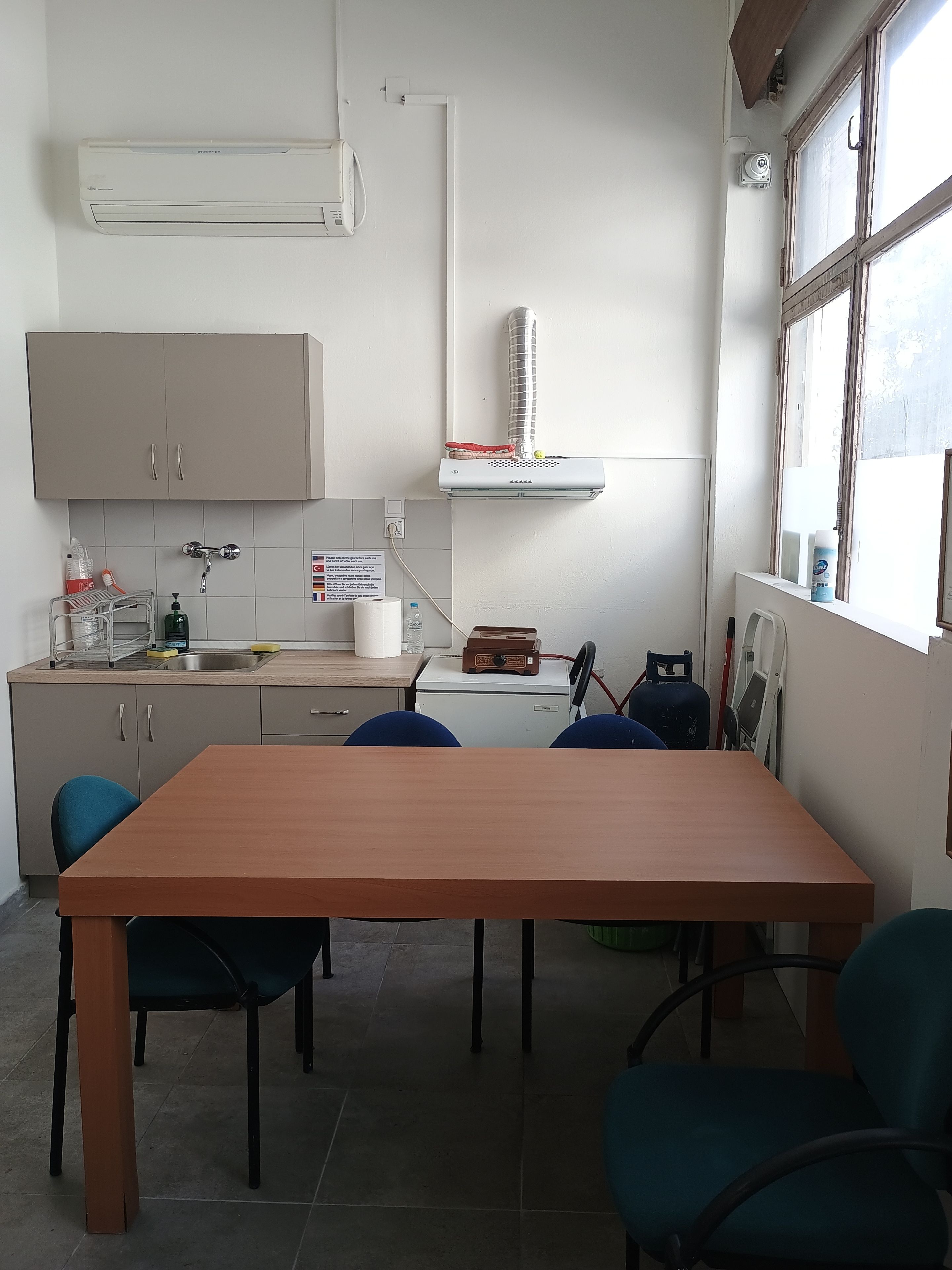 Une cuisine compacte comprenant une table à manger, des chaises et les équipements de base, comme un évier et des placards.