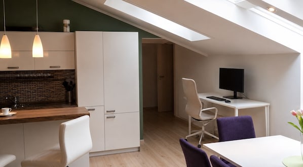 A modern kitchen with a dining area, a workspace, and a skylight. - Cassovia City Park Residence (Košice)
