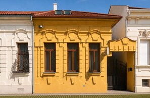 A building with three windows, a red-tiled roof, and a gated entrance. - Cassovia City Park Residence (Košice)