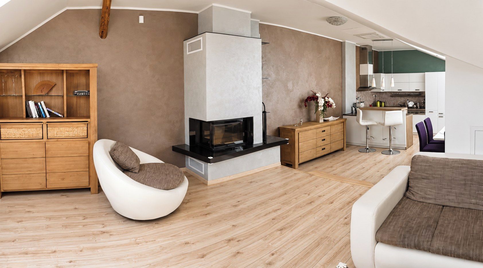 A modern living room with a fireplace, wooden furniture, and a kitchen area.