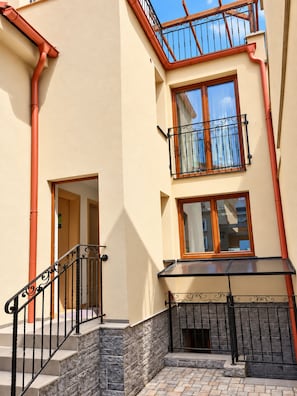 A multi-story building with a balcony, a staircase, and a window with a view. - Cassovia City Park Residence (Košice)