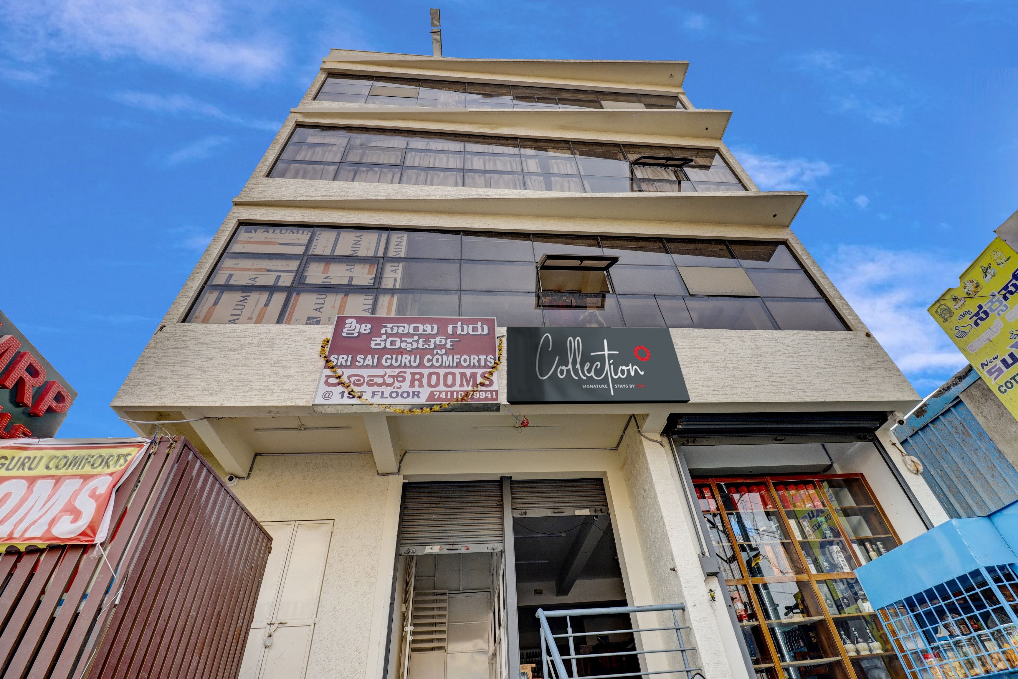 A multi-story building with signage for 'SRI SAI GURU COMFORTS' and 'Collection' on the ground floor.