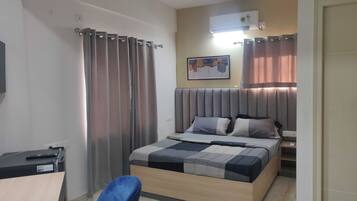 A modern bedroom with a bed, a desk, and a chair.