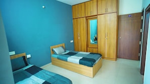 A bedroom with two beds, wooden wardrobes, and a mirror. - Hotel O Local Square Manyata (Bangalore)