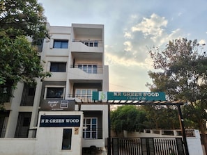 A multi-story building with a sign reading 'NR GREENWOOD Classic Life.' - Hotel O Local Square Manyata (Bangalore)