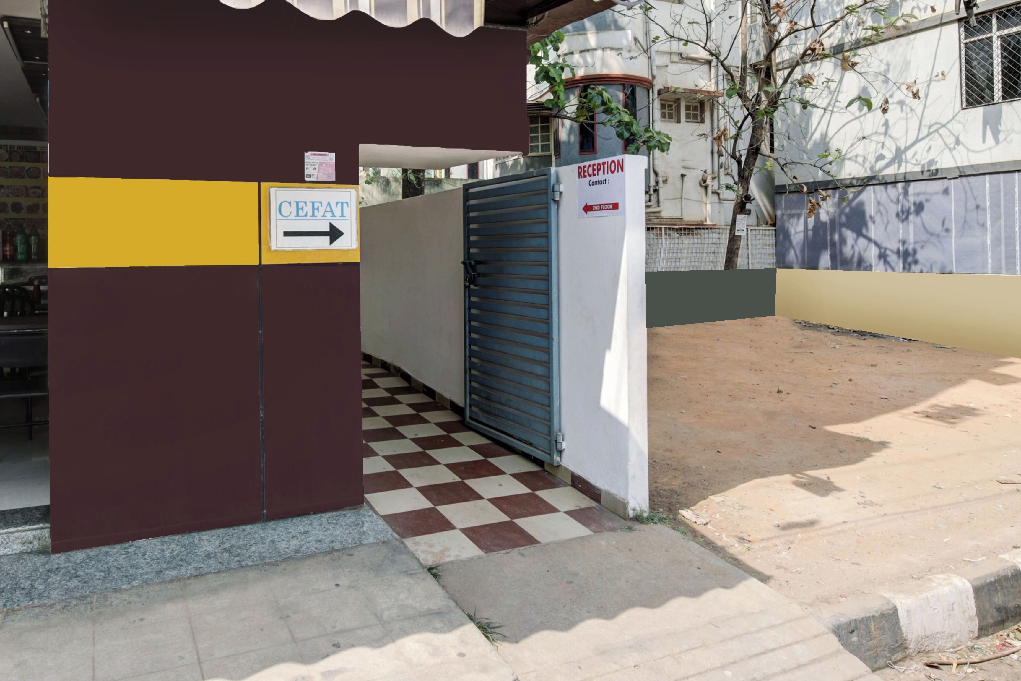 A building entrance with a reception sign, a directional arrow, and a gated area.