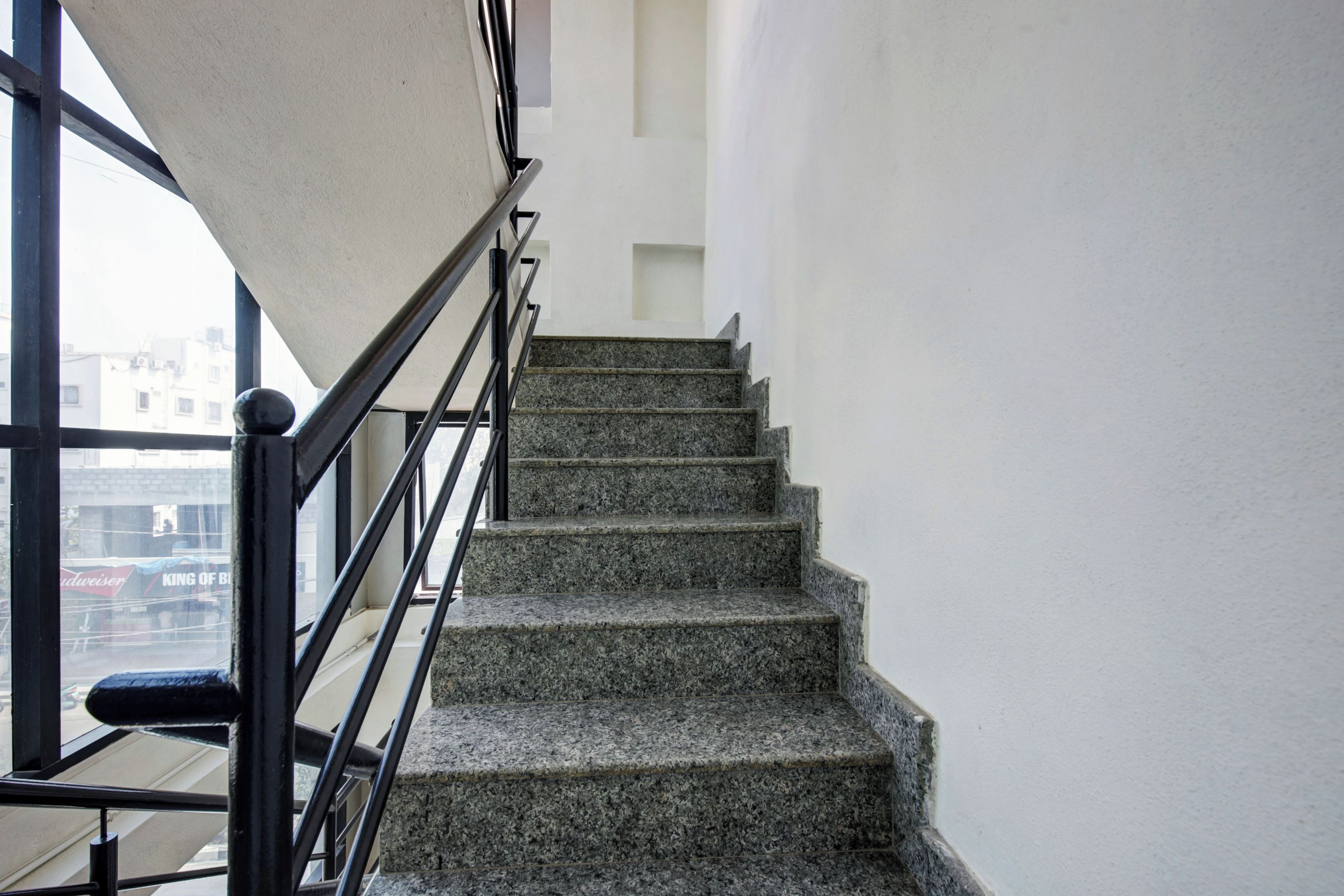 A staircase with granite steps and a black metal railing.
