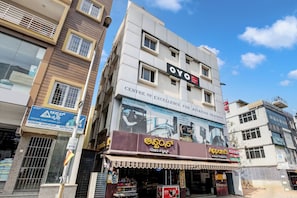 Un edificio de varios pisos con letreros que indican 'OYO' y 'KFC Comfort Rooms'.