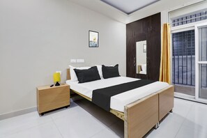 Quarto moderno com cama, mesa de cabeceira e janela com cortinas.