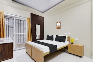 Quarto de hotel com cama, mesas de cabeceira, espelho, janela com cortinas e um quadro na parede.