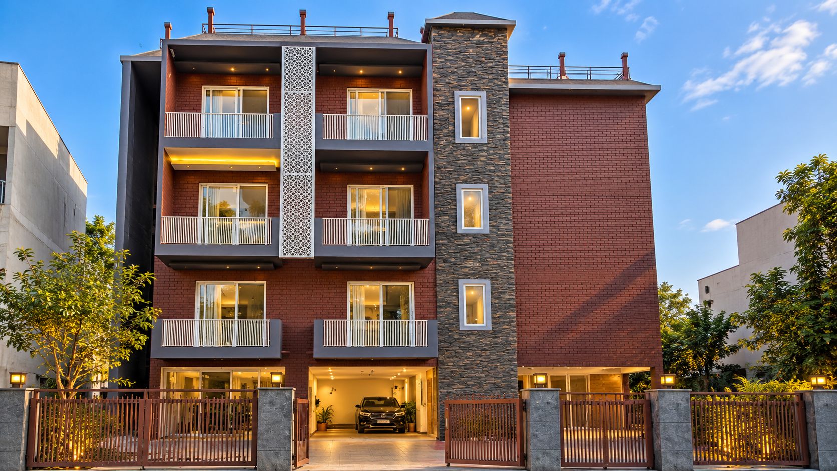 Un hotel de varios pisos con balcones, fachada de piedra y entrada protegida por una reja.