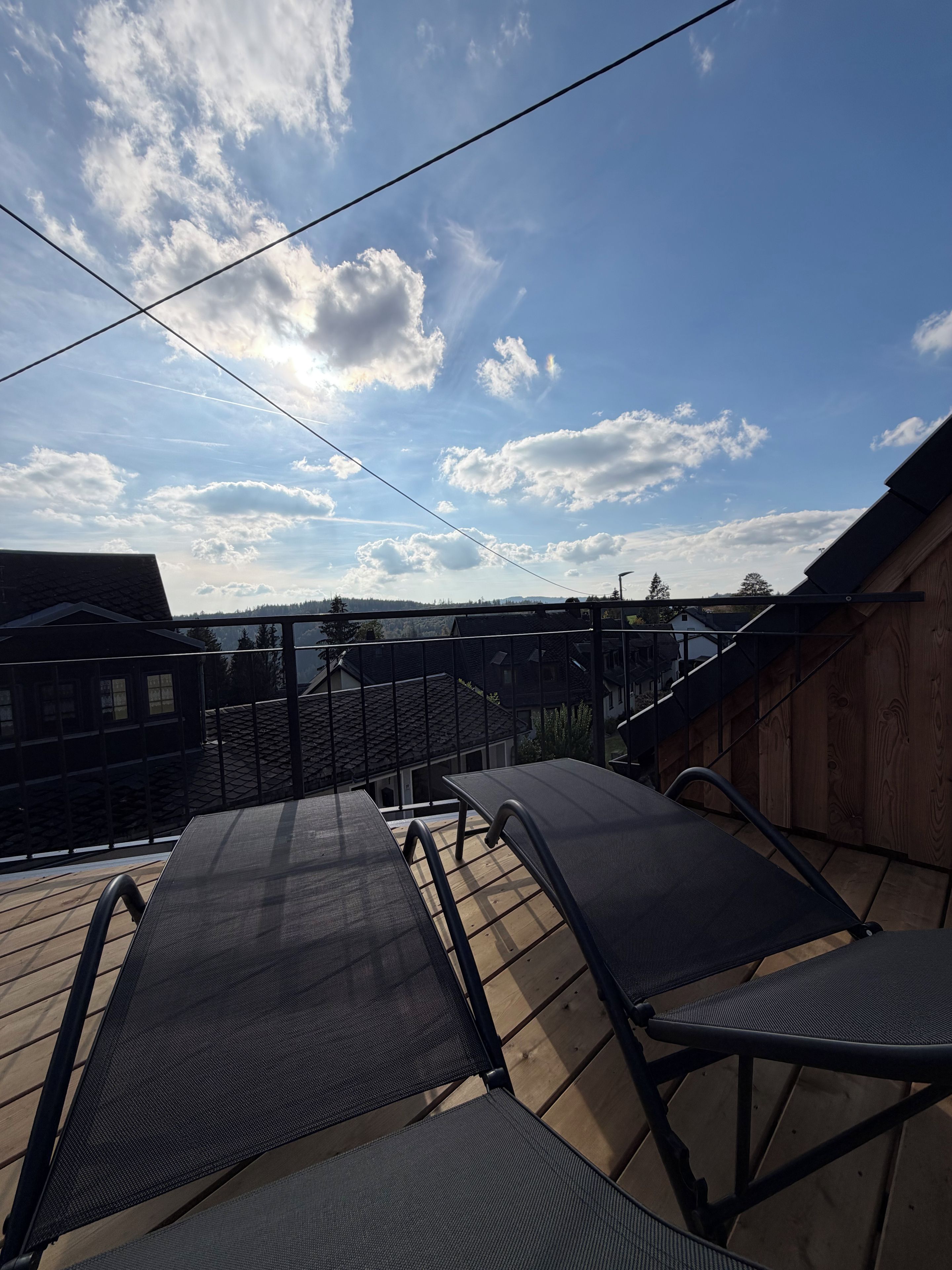 Eine Dachterrasse mit freiem Blick auf den Himmel und die umliegenden Gebäude.