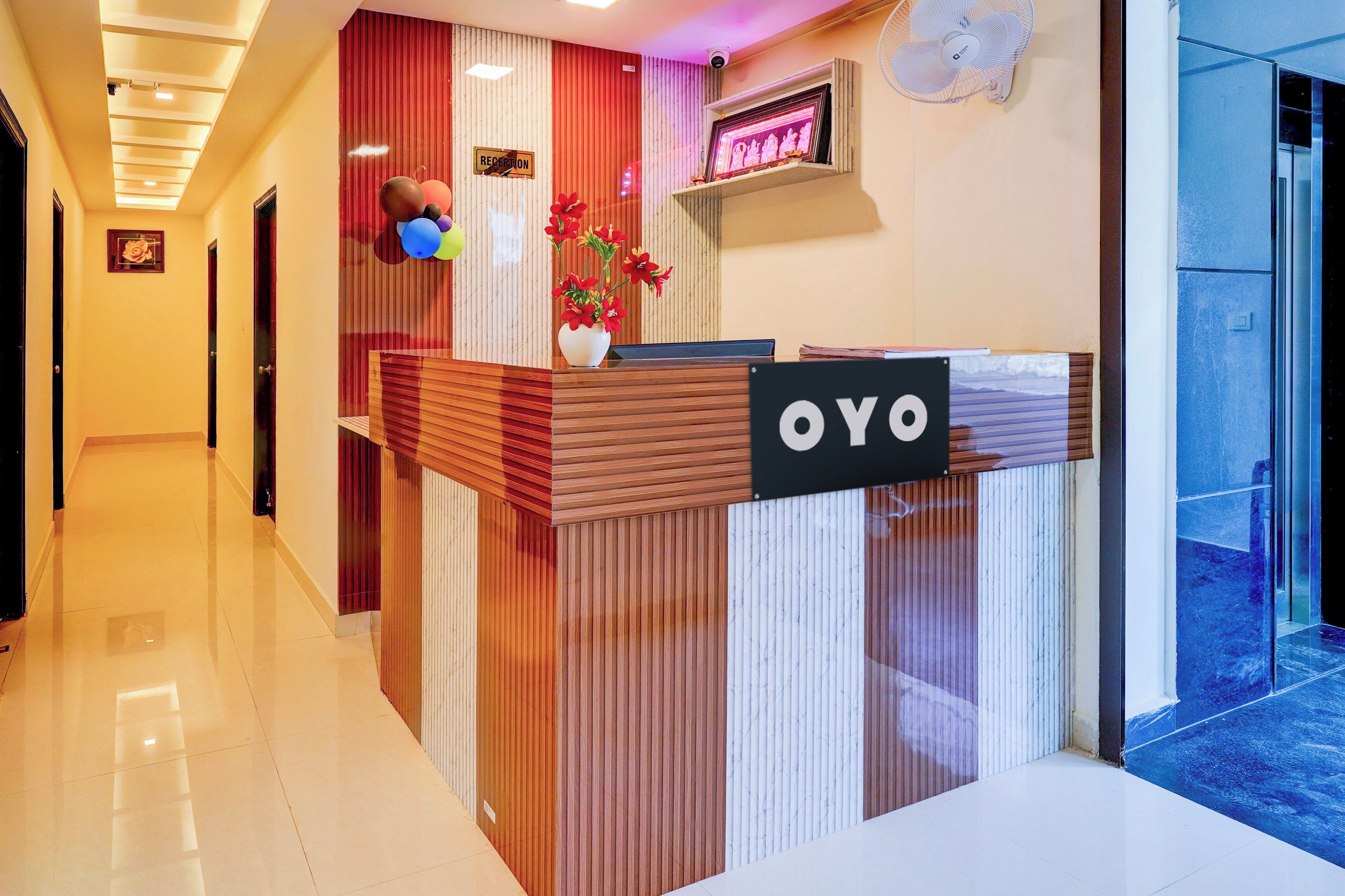 A reception desk with a 'YOYO' sign, a reception area with a camera, and a wall-mounted fan.