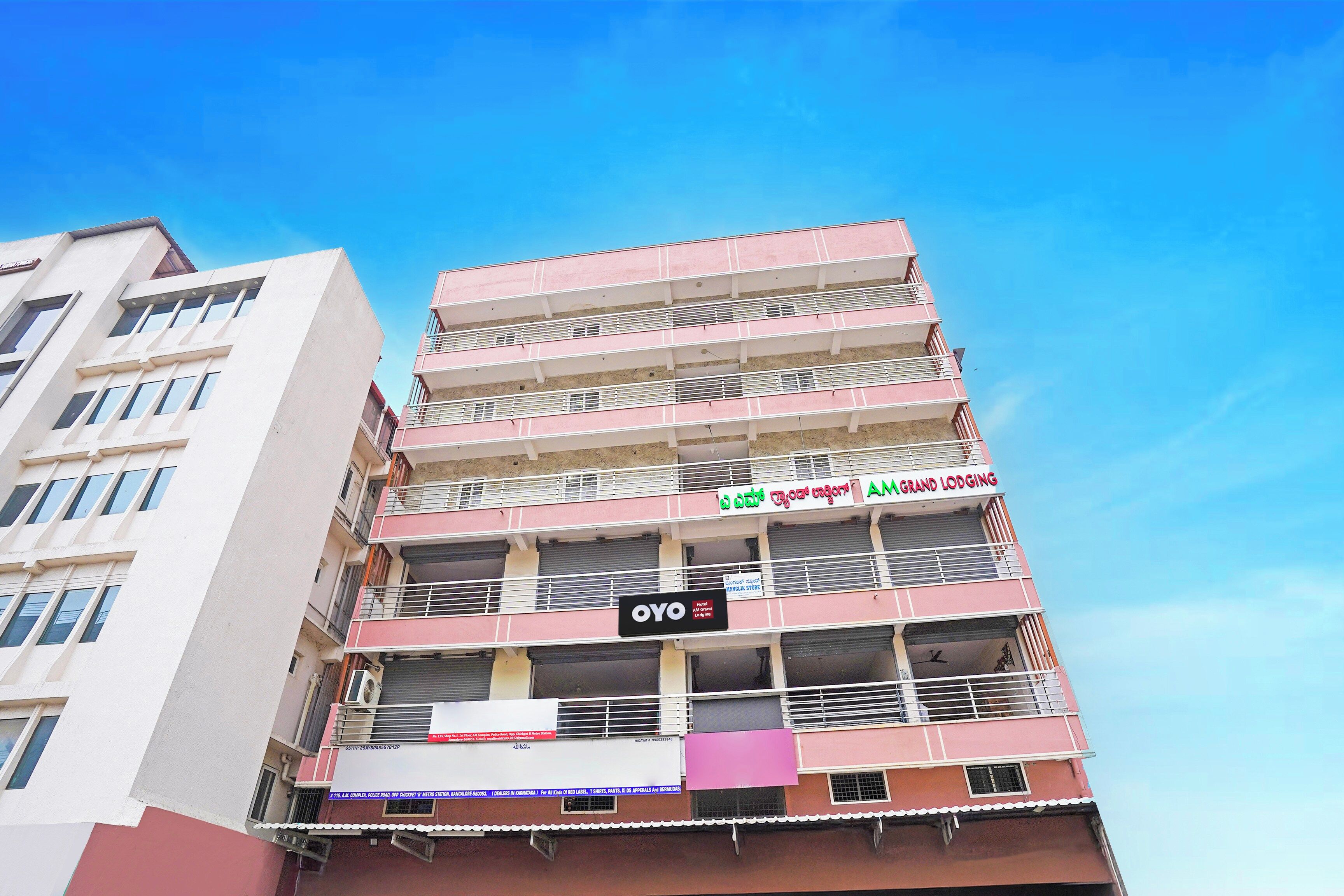 A multi-story hotel with balconies, signage for a grand lodging, and a visible awning.