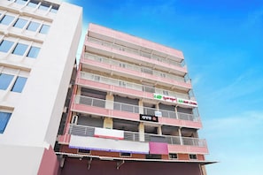 Monikerroksinen rakennus, jossa on parvekkeita sekä AM Grand Lodging- ja OYO-hotelliketjujen kyltit.