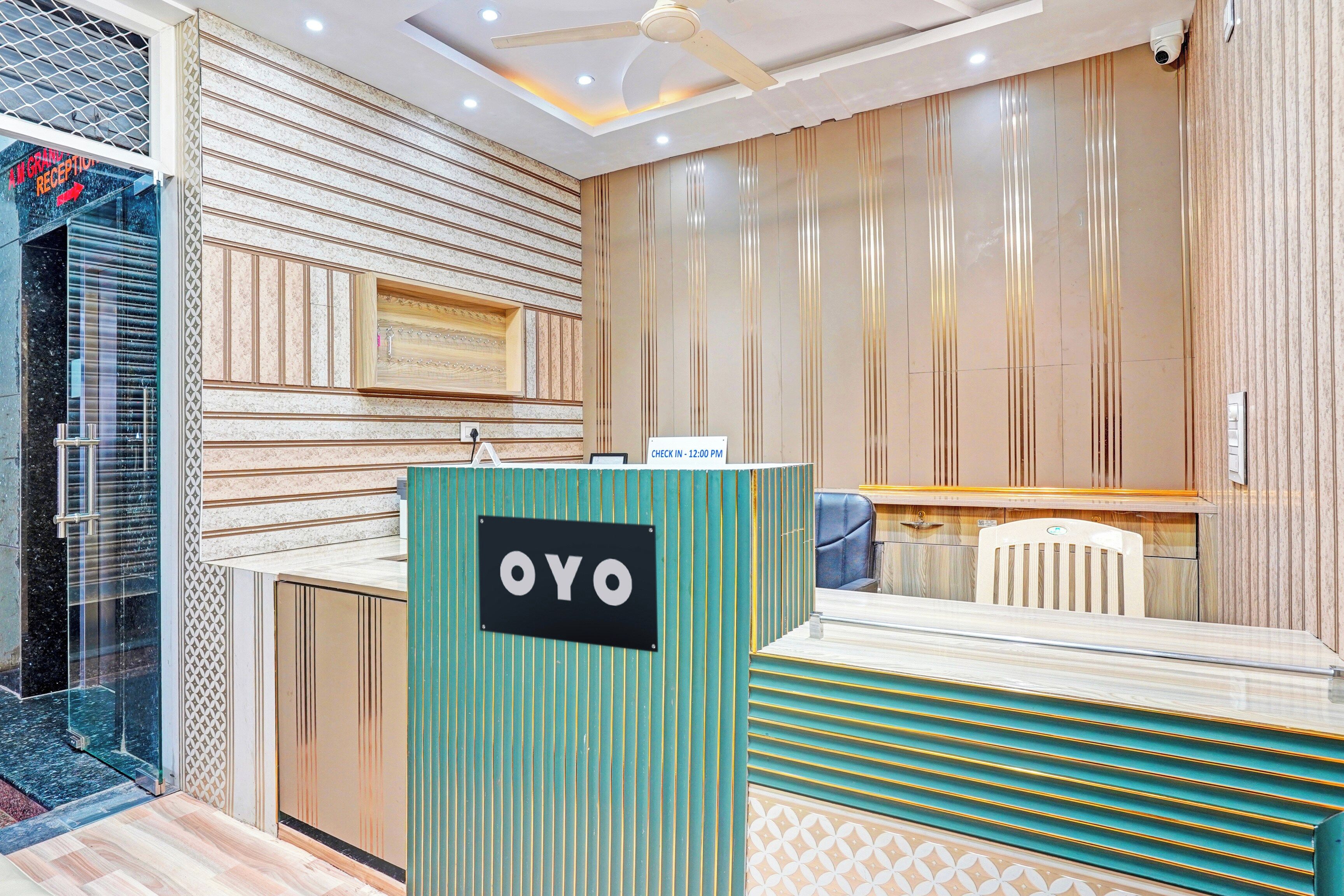 A reception area with a check-in desk, a reception desk with a sign, and a seating area with a chair.