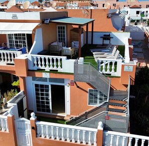 A multi-level building with balconies, a covered outdoor seating area, and a staircase. - 🌟 CASA MIMOSA Two Bedroom Apartment Central Caleta Pool Private Roof Terrace 🌟 (Castillo Caleta de Fuste)