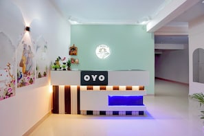 Una mesa de recepción con un letrero que dice 'OYO' y un logotipo encima.