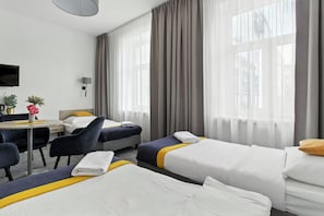 A hotel room with two beds, a desk, a chair, a TV, and a window with curtains. - Nest Apartament by Solarento (Warszawa)