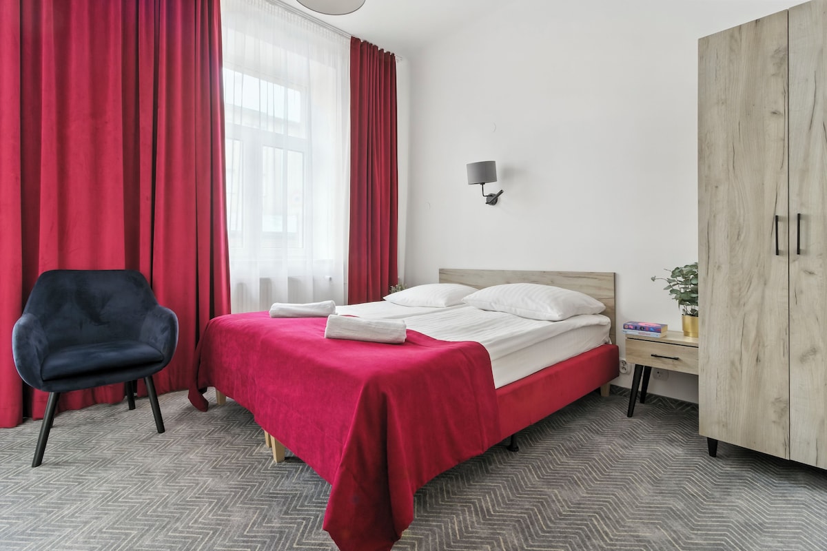 Une chambre d’hôtel avec un lit, une chaise, une armoire et une table de chevet.