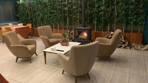 Una habitación con sofá, una mesa y estufa de leña.
