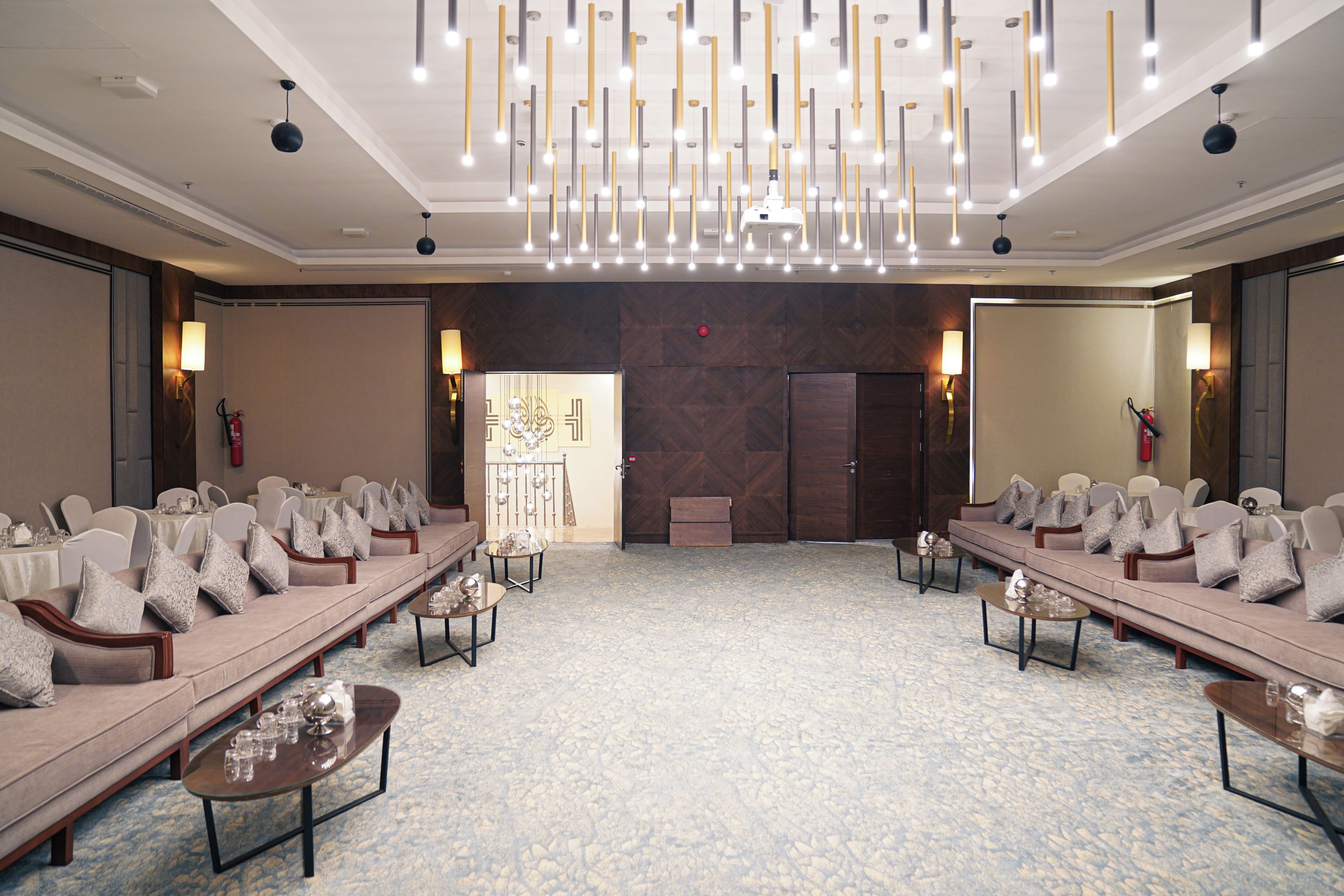 A conference room with a long table, sofas, and a patterned carpet.