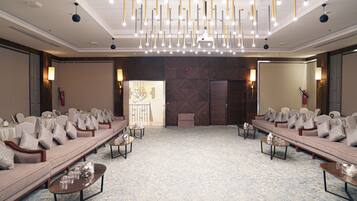 A conference room with a long table, sofas, and a patterned carpet.