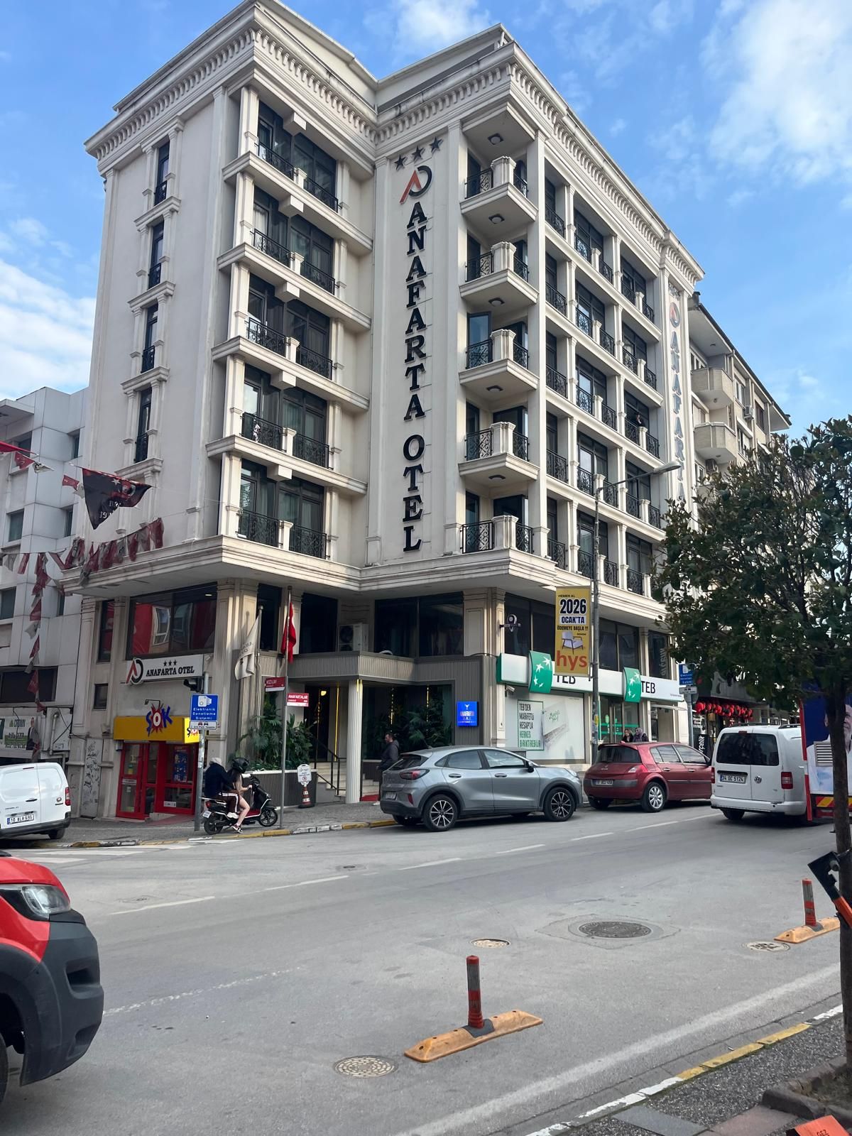Un hotel de varios pisos con un letrero llamativo que dice 'ANAPARTE HOTEL'.