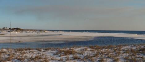 A beach with sand dunes and a clear sky.