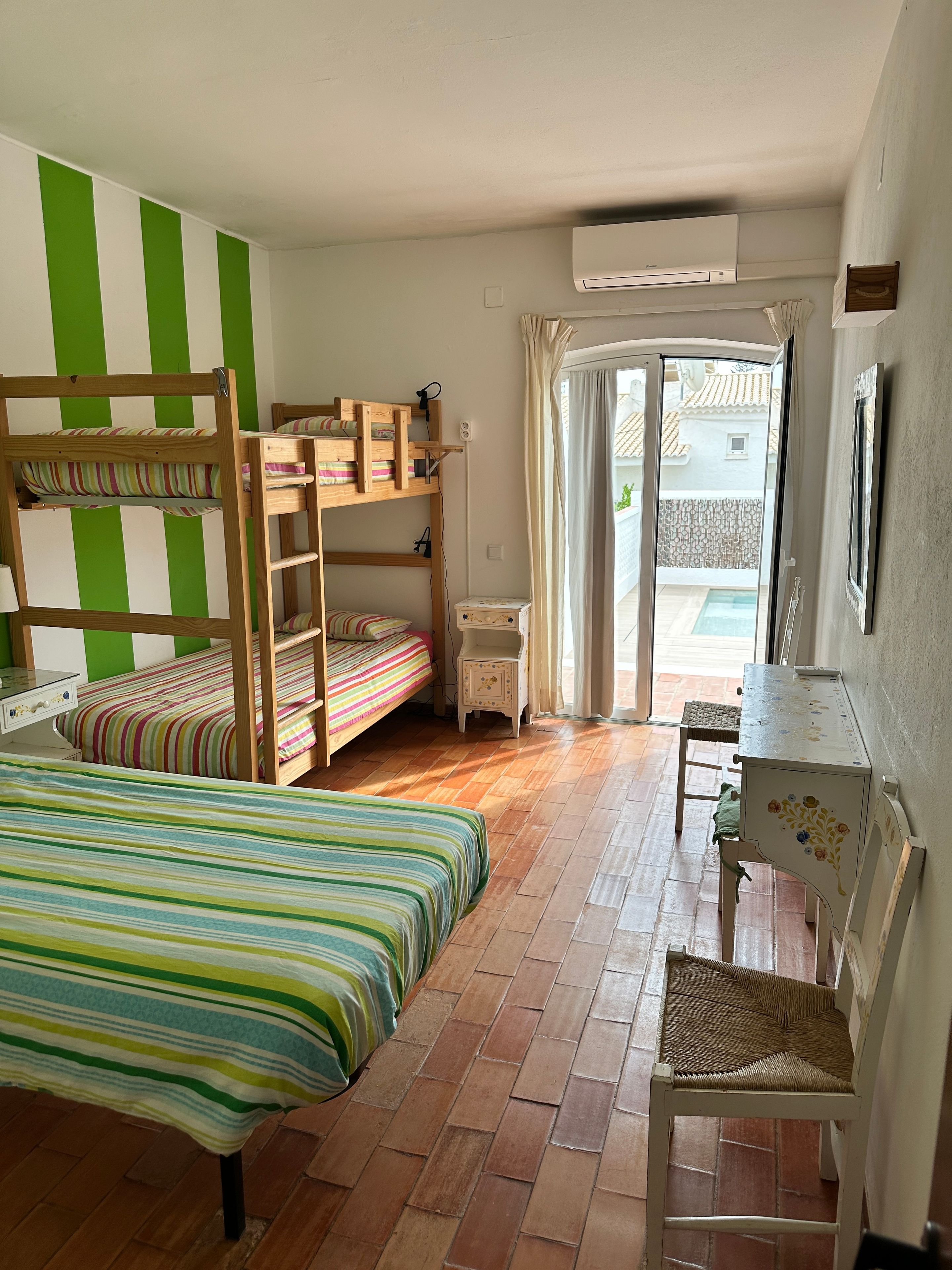 Quarto com beliches, uma escrivaninha e uma cadeira.